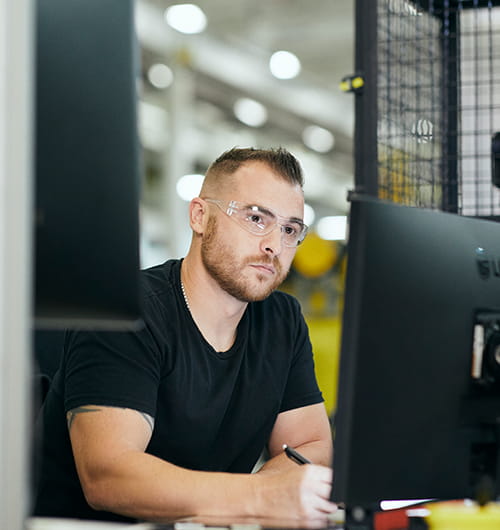 un homme devant un ecran dans l'usine.